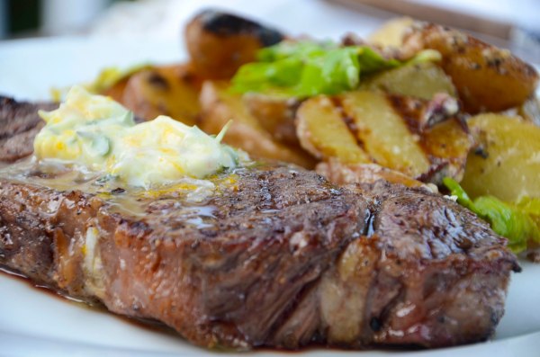 Grilled Strip Steak with Thyme Orange Shallot Compound Butter and Grilled Potatoes with Crumbled Bacon Vinaigrette.